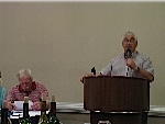 Jack Turley, sitting at the head table, with Tom Bernard speaking