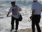 Pat Dege being chased by a wave as Carl Dege looks on
